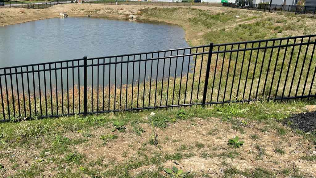 black aluminum fence on hill