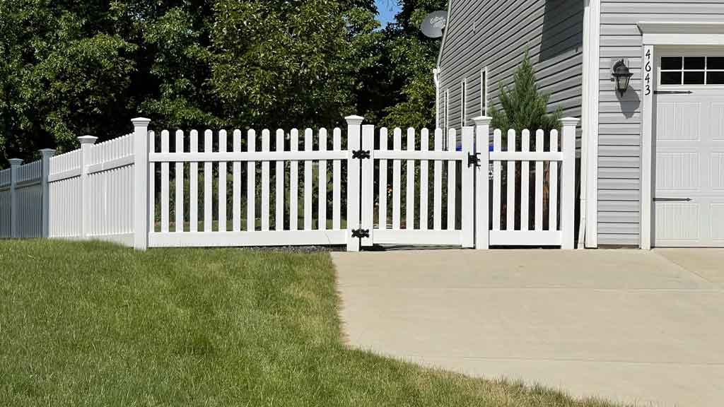 fence in yard with white picket fence