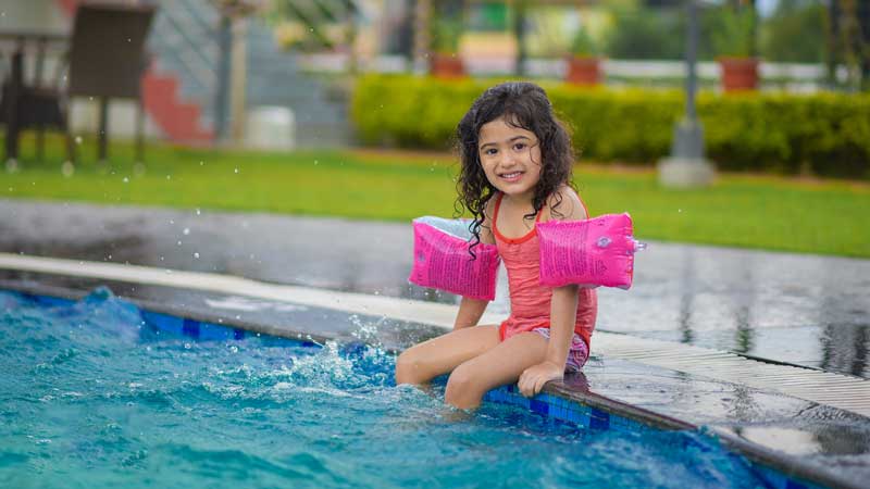 child sitting poolside